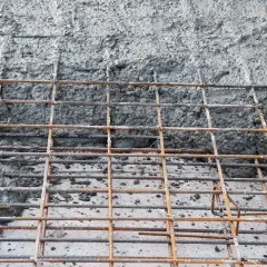 Siatka zbrojeniowa czeka na beton. Jaki beton na chudziaka będzie najlepszy? Ten szary, mokry materiał to właśnie on.