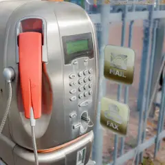 Stary unifon z pomarańczową słuchawką, obok ikony poczty i faksu.