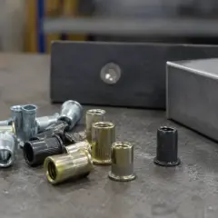 Zestaw nitonakrętek ze stali szlachetnej i innych metali, gotowych do montażu w elementach konstrukcyjnych.