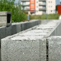 Pustaki zalewowe tworzą fundamenty nowego domu. W tle widać budynki mieszkalne.