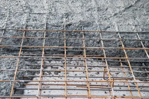 Siatka zbrojeniowa czeka na beton. Jaki beton na chudziaka będzie najlepszy? Ten szary, mokry materiał to właśnie on.