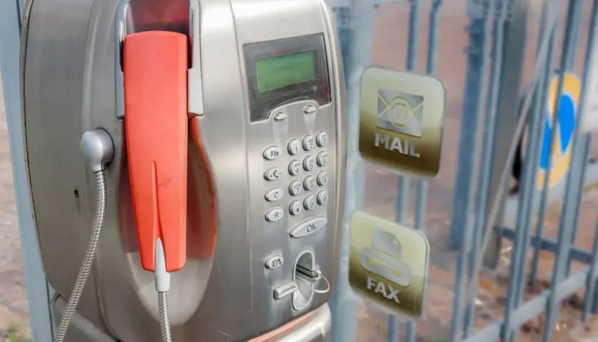 Stary unifon z pomarańczową słuchawką, obok ikony poczty i faksu.
