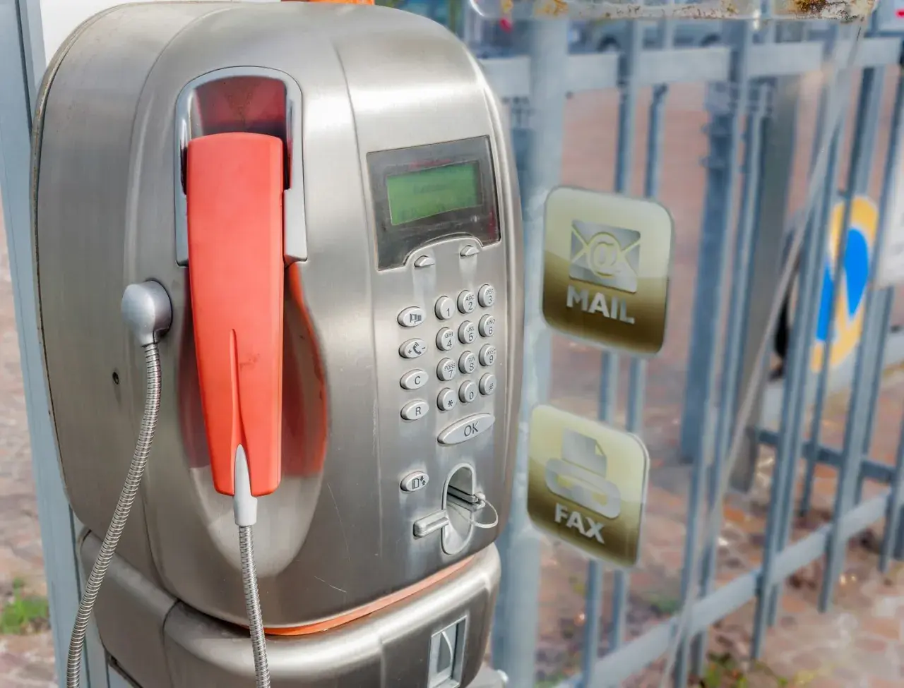 Stary unifon z pomarańczową słuchawką, obok ikony poczty i faksu.