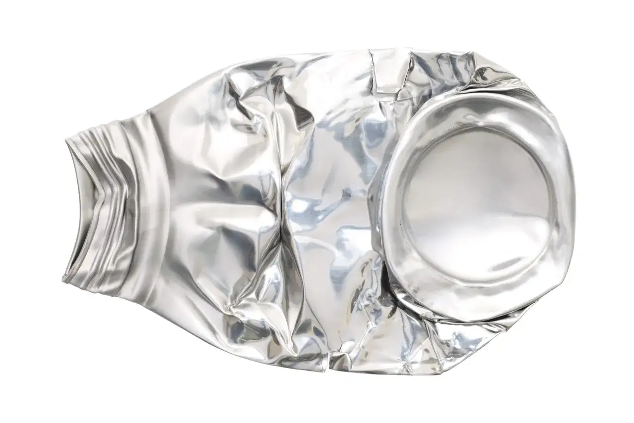 Zgnieciona puszka po napoju, wykonana z aluminium. Jej cena za kg jest zmienna, ale recykling jest zawsze opłacalny.